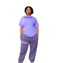a woman wearing a purple t - shirt and sweatpants