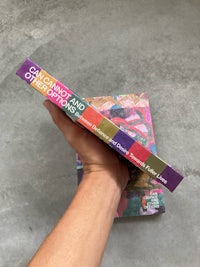 a person holding up a book with a colorful cover