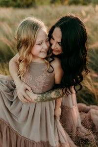 a mother and daughter hugging in a field