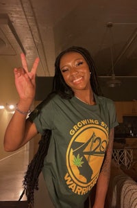 a woman wearing a green t - shirt with a peace sign