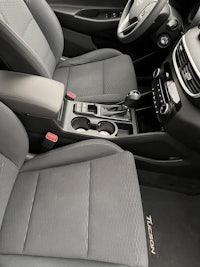 the interior of a car with gray seats and a steering wheel