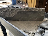 a piece of concrete is being placed in a wheelbarrow
