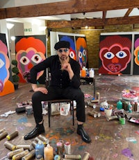 a man sitting on a chair in a room full of paint
