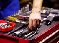 a man working with tools in a toolbox