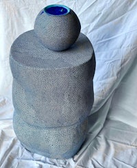 a blue vase on top of a white cloth