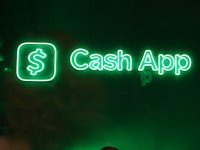 a woman is standing in front of a green neon sign that says cash app