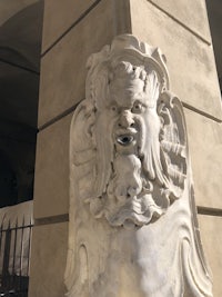 a statue of a man with a beard on the side of a building