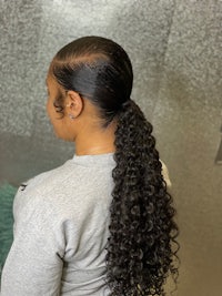 back view of a woman with curly hair in a ponytail