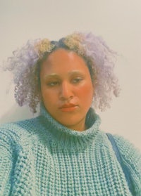 a woman in a green sweater with purple hair