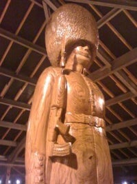 a wooden statue of a man wearing a hat