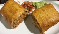 two burritos on a plate with guacamole and guacamole
