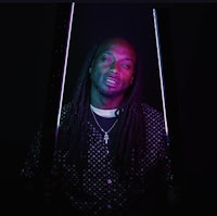 a man with dreadlocks holding a pair of neon sticks