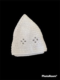 a white crocheted hat on a black background