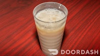 a glass of milky drink on a wooden table