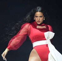 a woman in a red bodysuit performs on stage
