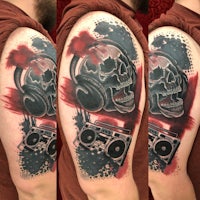 a tattoo of a skull with headphones and a boombox