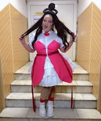 a woman in a pink and white dress posing on stairs