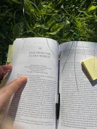 a person reading a book in the grass