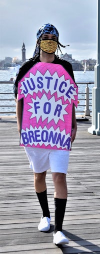 a woman wearing a mask and holding a sign that says justice for brema