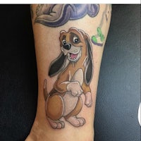 a tattoo of a cartoon dog on a person's leg