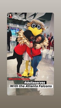 two women posing with a mascot at an airport