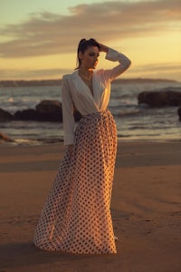 a woman in a polka dot skirt on the beach