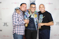 three men posing for a photo at an event