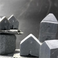 a group of small grey houses on top of a pile of rocks