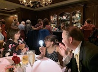 a group of people sitting at a table with a light bulb
