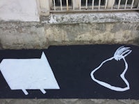 a black and white drawing of a cat and a dog on the sidewalk