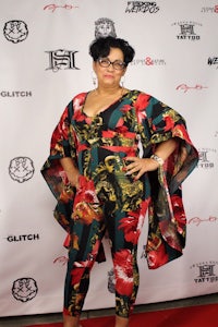 a woman in a floral jumpsuit standing on the red carpet