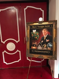 a framed picture of a man in a red coat on a red carpet