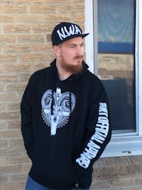 a man wearing a black hoodie with a skull and crossbones on it