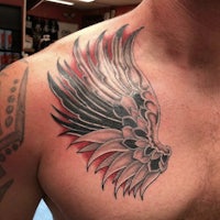 a man with an angel wing tattoo on his chest