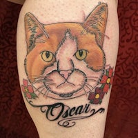 a tattoo of a cat with the name oscar