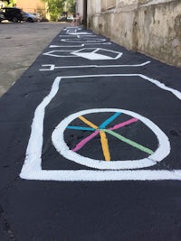 a sidewalk with a colorful drawing of a bicycle wheel