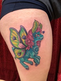 a tattoo of a fairy on the thigh