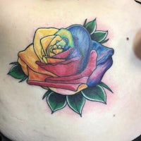 a rainbow rose tattoo on a woman's chest