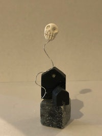 a sculpture with a skull and a house on top of it