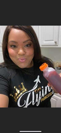 a woman is holding a bottle of juice