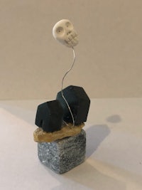 a sculpture with a skull on top of a rock