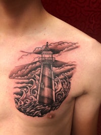 a tattoo of a lighthouse on the chest