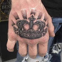 a hand with a crown tattoo on it