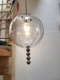 a glass ball hanging from a wooden shelf