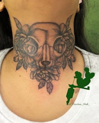 a woman's neck tattoo with a skull and flowers
