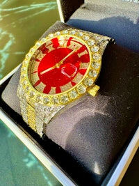 a red and gold watch sitting in a box