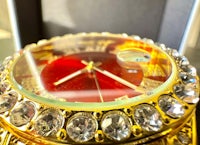 a gold watch with red crystals on it