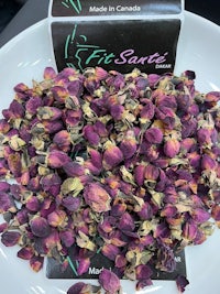 a pile of dried rose petals on a white plate