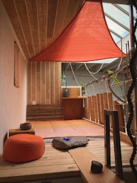 a room with a wooden floor and a red canopy