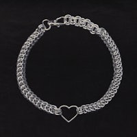 a silver chain bracelet with a heart on it